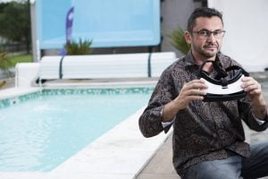 O franqueado da iGUi, que fabrica piscinas, Charlles Coura com óculos de realidade virtual, em sua loja na zona leste de São Paulo - Rafael Hupsel/Folhapress